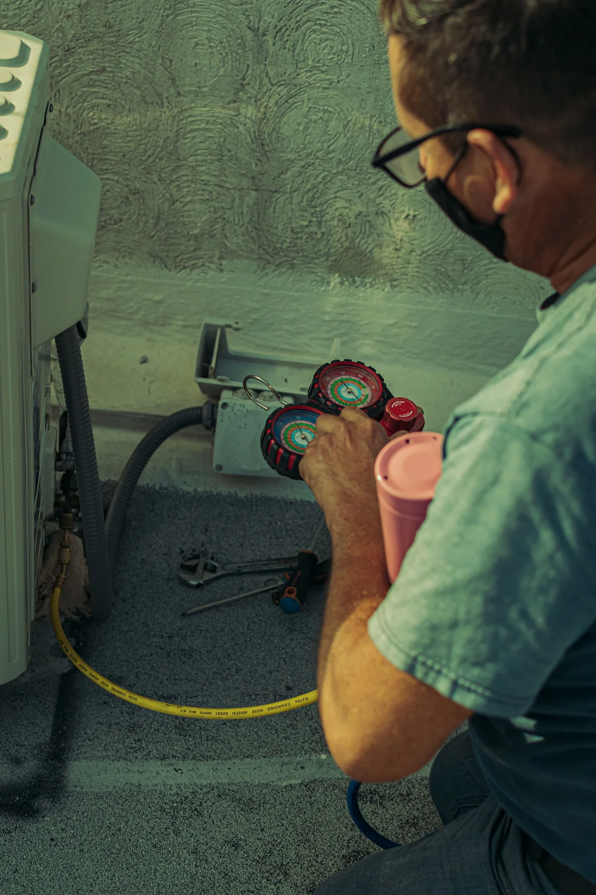 Technician checking the pressure gauges on an air conditioning system