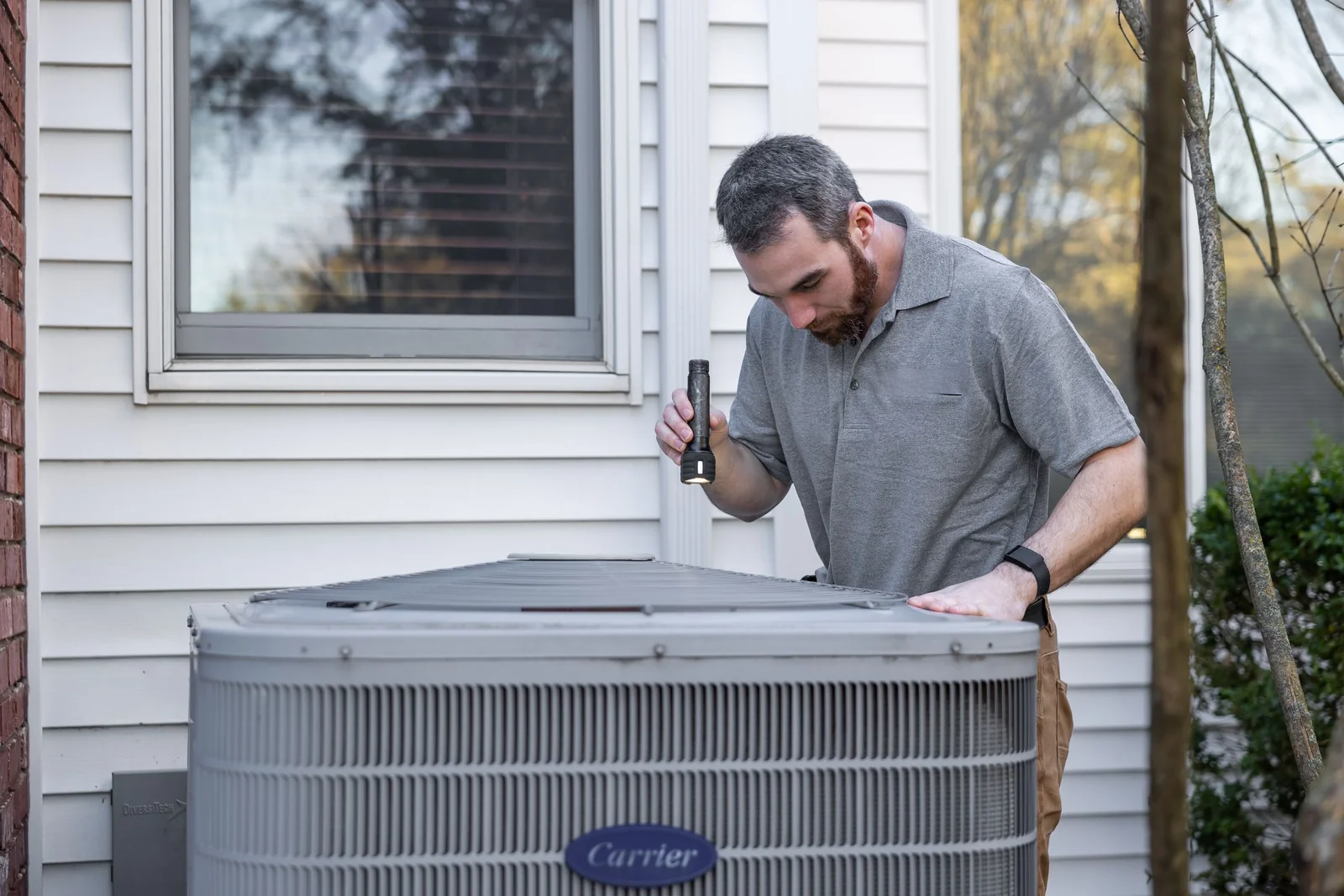 Un técnico inspecciona un sistema de climatización en el exterior.