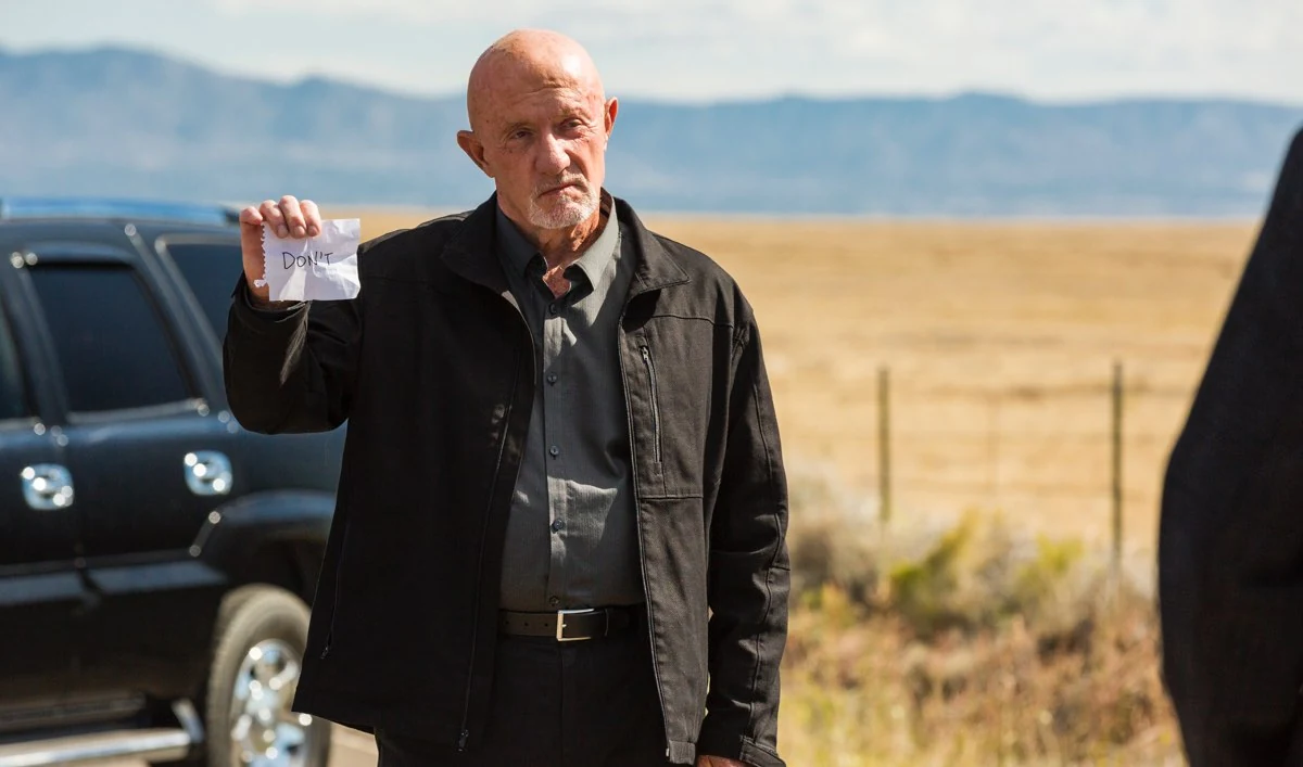 Mike Ehrmantraut holding a note that reads DON'T