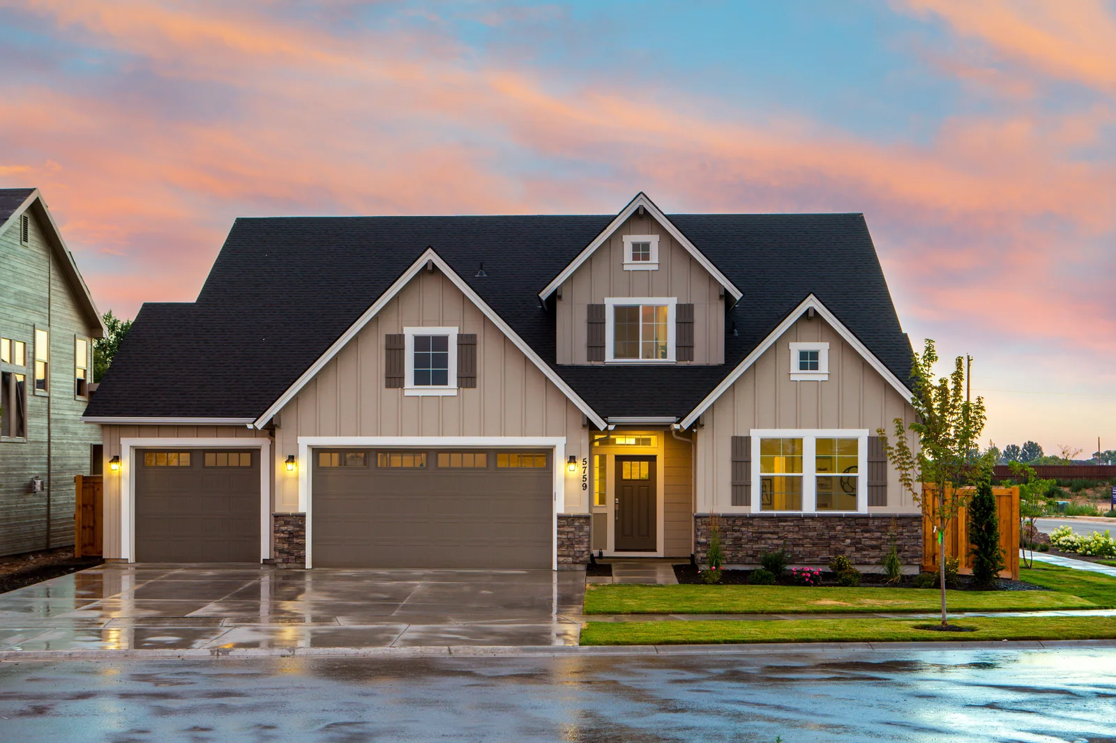 Residential home with a broad shingle roof at sunset